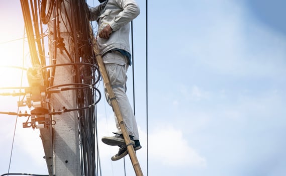 The technician is repairing the cables on the electric pole. photo