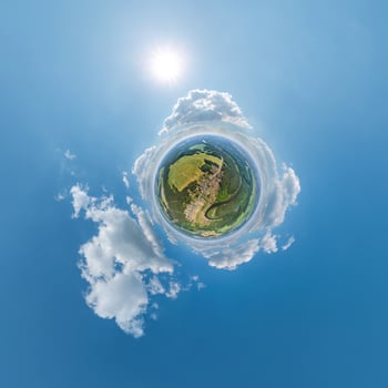 simple little tiny planet without buildings in blue sky with sun and beautiful clouds. Transformation of spherical panorama 360 degrees. Spherical abstract aerial view. Curvature of space. photo