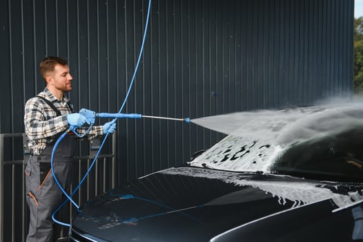 Car Wash Specialist Using Pressure Washer to Rinse a car photo