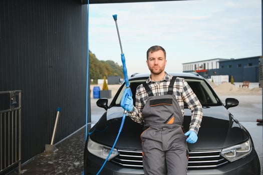 Man worker washing car service. Car wash cleaning station high pressure water. Employees clean a vehicle professionally photo