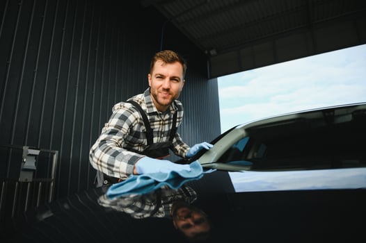 Man worker washing car service. Car wash cleaning station high pressure water. Employees clean a vehicle professionally photo