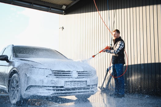 Car is washed at a professional car wash. Man washes a car with foam. Detailing photo