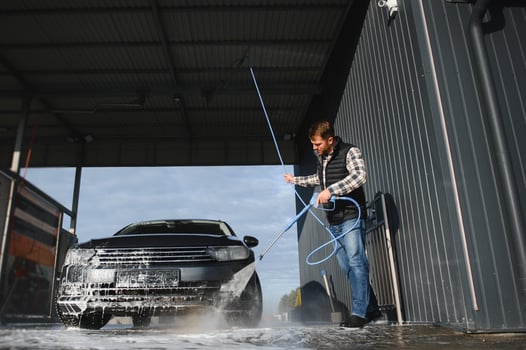 A man washes his car at a car wash. Self service car wash. photo