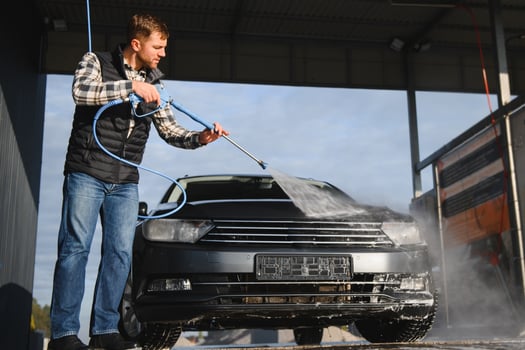 A man washes his car at a car wash. Self service car wash. photo