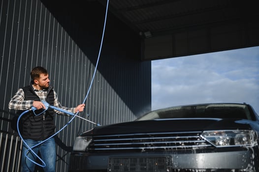 A man washes his car at a car wash. Self service car wash. photo