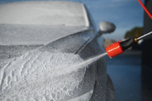 Car is washed at a professional car wash. Man washes a car with foam. Detailing photo