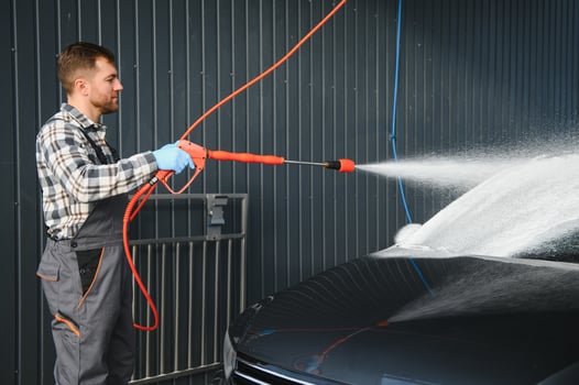 Car Wash Specialist Using Pressure Washer to Rinse a car photo