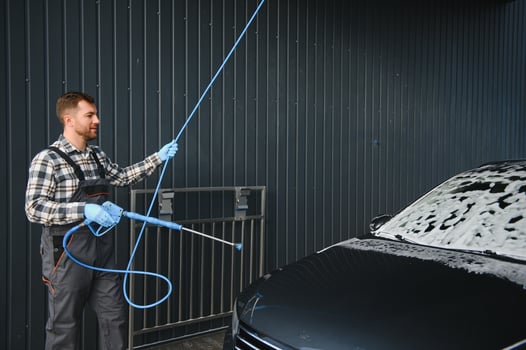 Car Wash Specialist Using Pressure Washer to Rinse a car photo