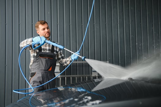 Car Wash Specialist Using Pressure Washer to Rinse a car photo