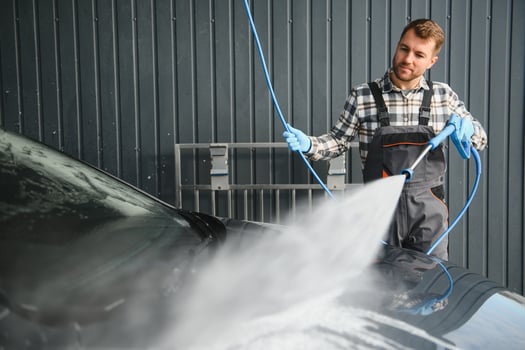 Car Wash Specialist Using Pressure Washer to Rinse a car photo