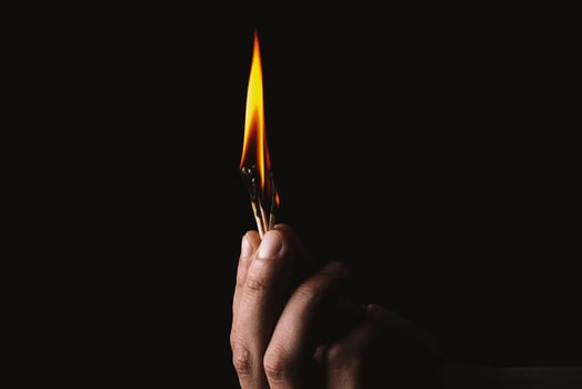 Burning match in the man's hand. Dangerous game with fire. photo