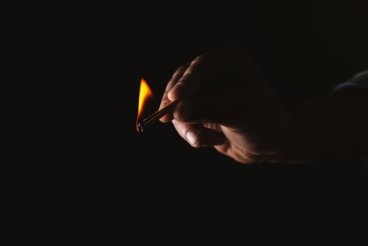 Burning match in the man's hand. Dangerous game with fire. photo