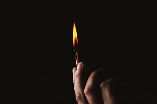 Burning match in the man's hand. Dangerous game with fire. photo