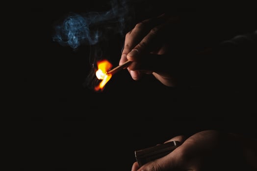 Burning match in the man's hand. Dangerous game with fire. photo