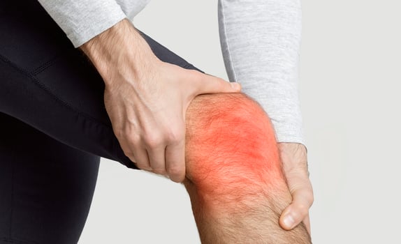 Knee pain concept. Inflammation highlighted in red, free space photo