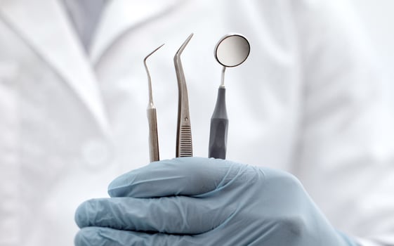 Unrecognizable Dentist Doctor In Blue Sterile Glove Holding Dental Tools In Hand, Demonstrating Mouth Mirror, Probe And Stainless Tweezers, Creative Banner For Quality Stomatological Services photo