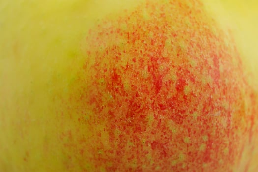 Red apple with yellow color as background. photo