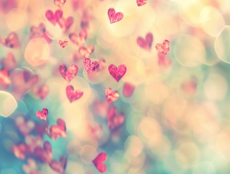 Sparkling red hearts falling on a bokeh background. photo