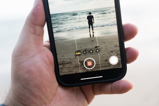 Shooting with phone. Shooting man walking at the beach photo