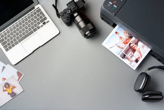 Printer, laptop and camera on table close up. Printing photos