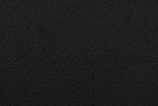 Stucco black wall of an old house. Abstract dark texture. photo