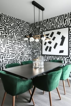 Modern dining area featuring bold wall art and stylish green chairs in a contemporary home photo
