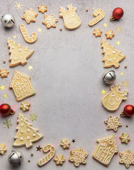 Christmas gingerbread cookies and ornaments creating festive frame on grey background photo