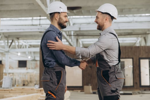 Construction workers shaking hands in modular building industry photo