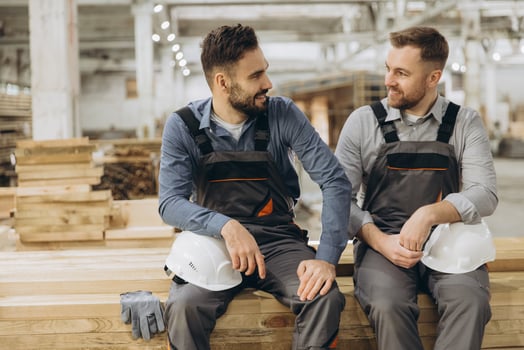 Construction workers discussing project in lumber warehouse photo