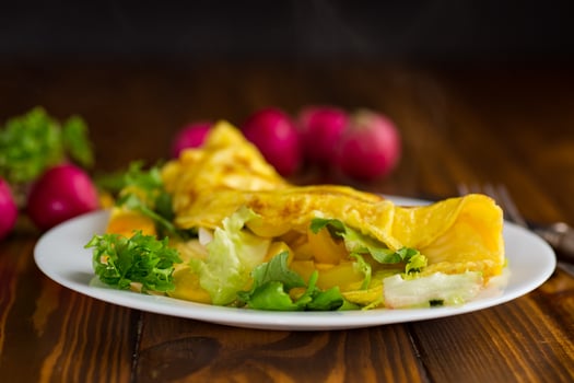 egg roll with sweet pepper and salad, on a wooden table . photo