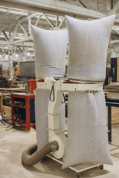 Industrial dust collector removing sawdust in carpentry workshop photo