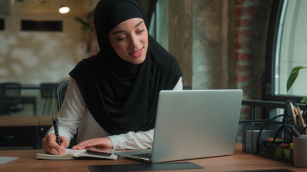 Muslim Arabian islamic girl in hijab smiling woman female businesswoman saleswoman laptop call online confrence pointing on paper document discuss report sales graph business presentation office photo