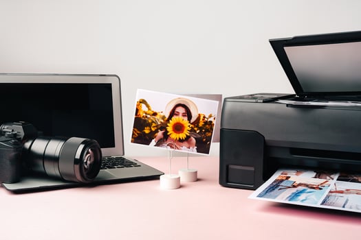 Printer, laptop and camera on table close up. Printing photos