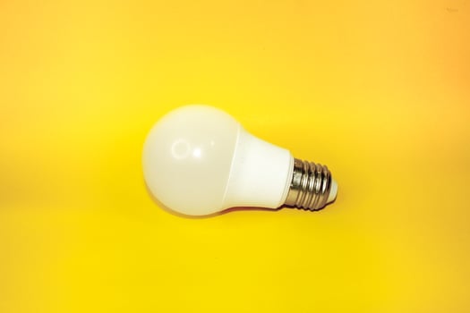A bulb that is placed flat against a yellow background. photo