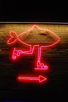 Bright and colorful Neon Fish Sign featuring an Arrow Direction for your attraction needs photo