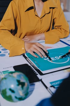 A woman is working on a laptop with a pen and a globe photo