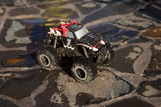 The Exciting RemoteControlled Monster Truck Designed for Action on a Stony Surface photo