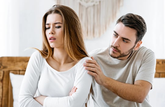 Reconciliation in family. Man consoles an offended woman in interior at bedroom. photo