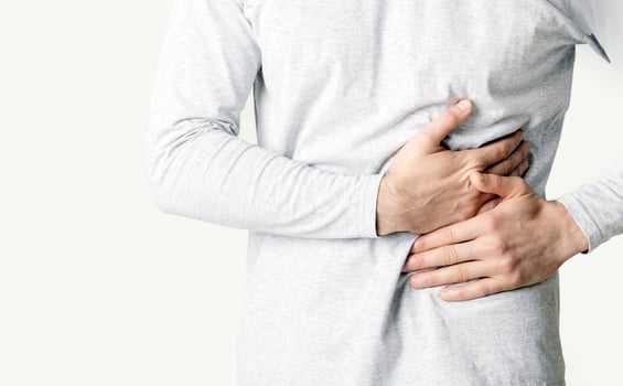 Liver disease concept. Man presses hands to his side, cropped photo