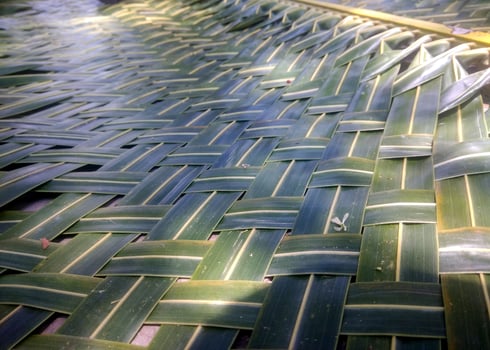 A close-up of a woven mat made from coconut leaves highlights its intricate pattern, natural green-brown hues, and craftsmanship, symbolizing traditional, eco-friendly, and cultural heritage. photo