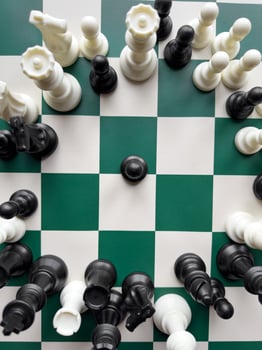 Dynamic chess game with vibrant black and white pieces on a checkered board photo