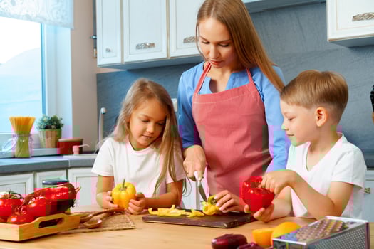 Mother cooking with her children in kitchen photo