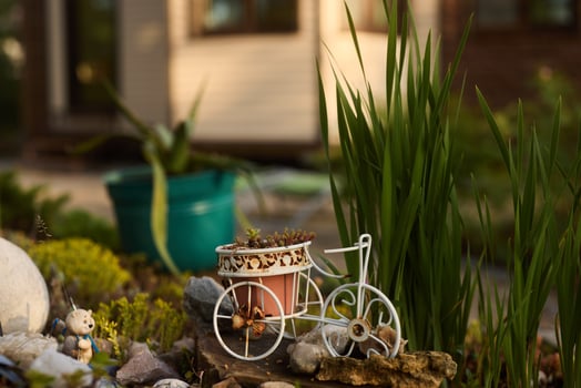 Charming Garden Decor Featuring a Miniature Bicycle Surrounded by Lush and Vibrant Greenery photo
