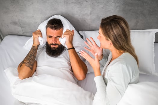 Couple is lying in bed and arguing. The woman is angry with the man. photo
