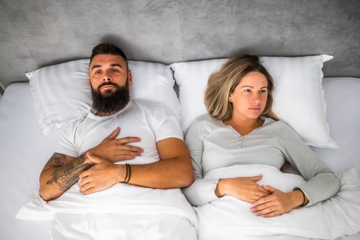 Couple is lying in bed. They are angry and not talking to each other. photo