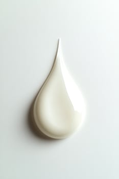 Top view of a drop of white cream on white background photo