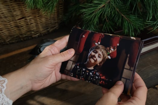 Female Hands Holding Printed Christmas Photos for Family Picture Album