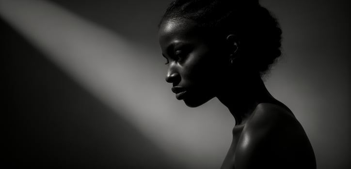 A black and white photo of a woman in the shadows