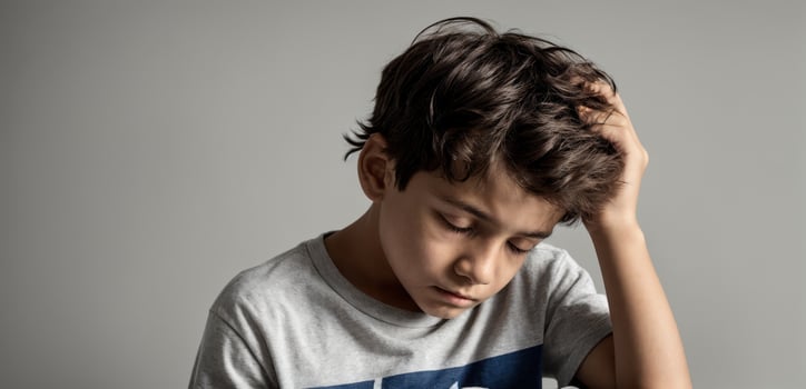 A boy is holding his head in his hands photo