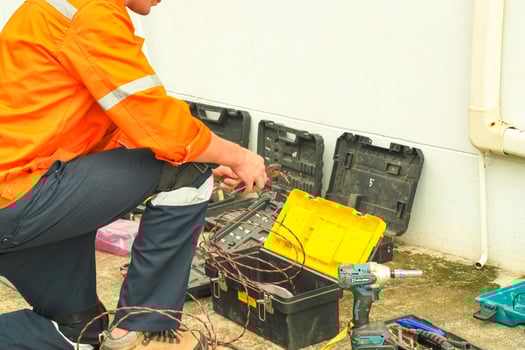 A man in an orange shirt and orange pants is working on a toolbox photo